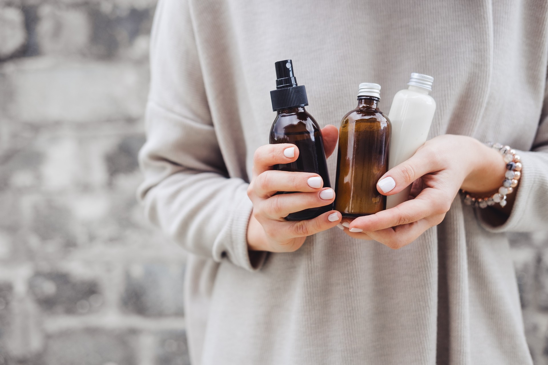 Woman holds bottle with spa cosmetics